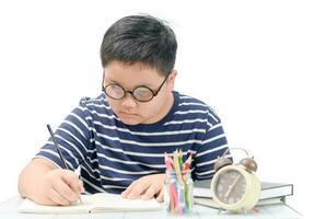 grasa chico estudiante escritura en libro aislado foto