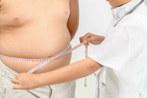 pequeño médico medición obeso niño cintura cuerpo grasa aislado foto