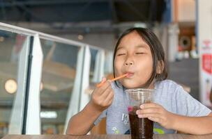 Happy girl drinking cola Smoothie From Plastic Cup photo