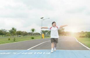 contento asiático grasa chico corriendo a el terminado línea. foto