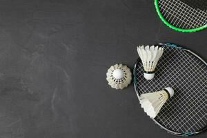 Shuttlecocks and badminton racket on black background. photo