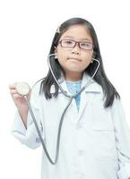 retrato de linda pequeño niña médico participación estetoscopio aislado en blanco fondo, salud cuidado concepto foto