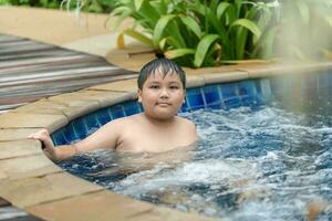 Obese boy relaxing enjoying hot tub bubble bath photo
