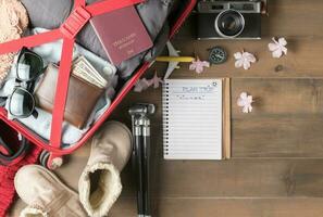 plan viaje en cuaderno y preparar accesorios y viaje artículos para invierno foto