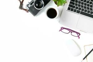 White office desk table with laptop computer and vintage camera photo