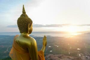 Buddha statue with sunrise and Pa Sak Jolasid Dam photo
