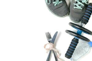 Sneakers and fitness wheel on white background photo