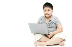 grasa chico estudiante sentado con ordenador portátil aislado foto