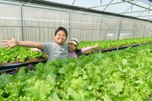 contento niños son presentación con mano a orgánico vegetal granja foto
