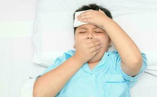 Sick child is coughing and compress on forehead. photo