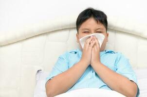 fat boy has runny nose and blows nose into tissue photo