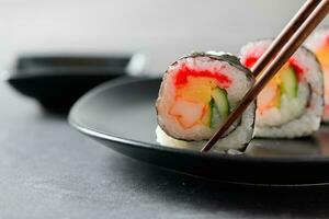 sushi rolls Vegetable, Inari and  Crab Sticks with chopsticks photo