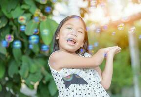 Happy asian girl play bubble soap at home photo