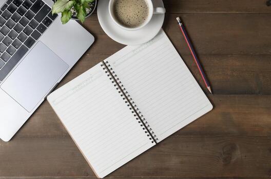 Old wooden office desk table with blank notebook, laptop computer photo