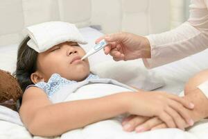 Mother checking temperature of her sick daughter. photo