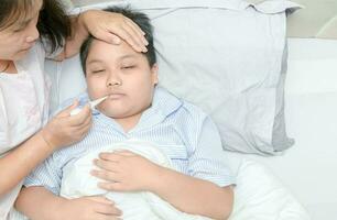 madre medición temperatura de enfermo niño. foto