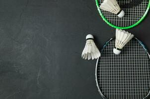 Shuttlecocks and badminton racket on black background. photo