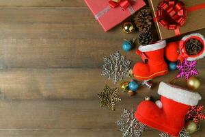 Small santa claus boot with decorations and gift boxes on wooden photo