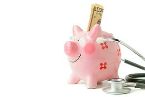 Banknote in piggy bank and Stethoscope  isolated photo