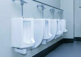 row of urinal toilet blocks in public restroom photo