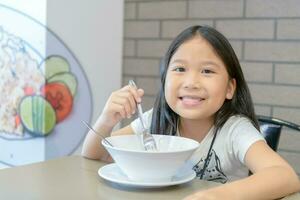 Cute girl eating noodle in food court photo