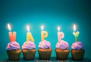 pink cup cake with candle Happy on blue background photo