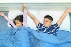 Children are stretching in bed after waking up, photo
