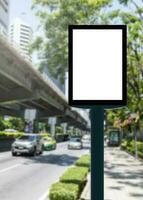 Outdoor pole vertical light box billboard with mock up white screen on footpath and clipping path photo