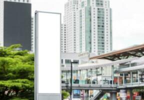 Mock up white LED display vertical billboard on tower pole with cityscape view. clipping path for mockup photo