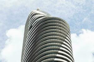 Bottom up view modern buliding hotel with blue sky background photo