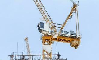 Tower construction crane in rooftop building construction site with blue sky background photo