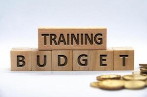 Training budget text engraved on wooden blocks on white background cover. Business and budgeting concept photo