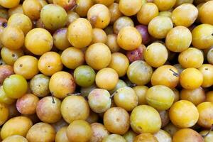 Stack of Mirabelle plums on a market stall photo