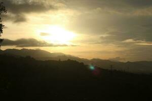 The sun rises over the mountains photo