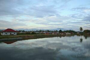 A village by the water with mountains in the background photo