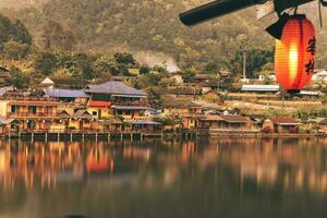 Chinese lanterns and boats in lake with sunset over Ban Rak Thai photo