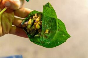 Thai Leaf Wrap Salad Bite Miang Kham in hand photo