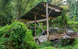 Old truck under wooden shelter - Views between Mae Hong Son and Ban Rak Thai photo