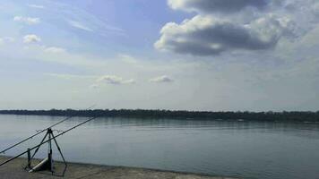 Fishing on a river. Two fishing rods standing on the bank early in the morning. video