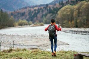 woman on the river bank in the forest and mountains in the background landscape tourism travel photo
