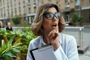 Business woman in white shirt on the street with work documents photo