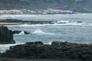 Large waves crashing against the rocks in the ocean photo