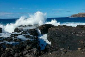 Large waves crashing against the rocks in the ocean photo