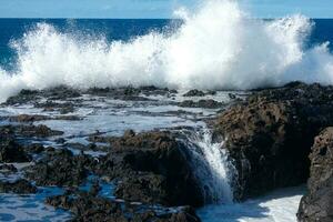 Large waves crashing against the rocks in the ocean photo