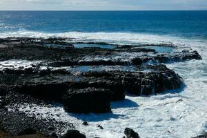 Large waves crashing against the rocks in the ocean photo