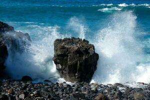 Large waves crashing against the rocks in the ocean photo