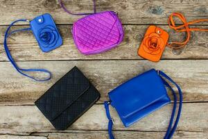 Colored handbags on wooden background. Top view. photo