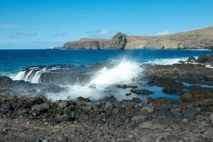 Large waves crashing against the rocks in the ocean photo