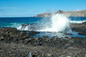 Large waves crashing against the rocks in the ocean photo