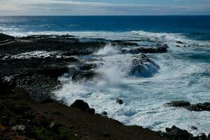 Large waves crashing against the rocks in the ocean photo